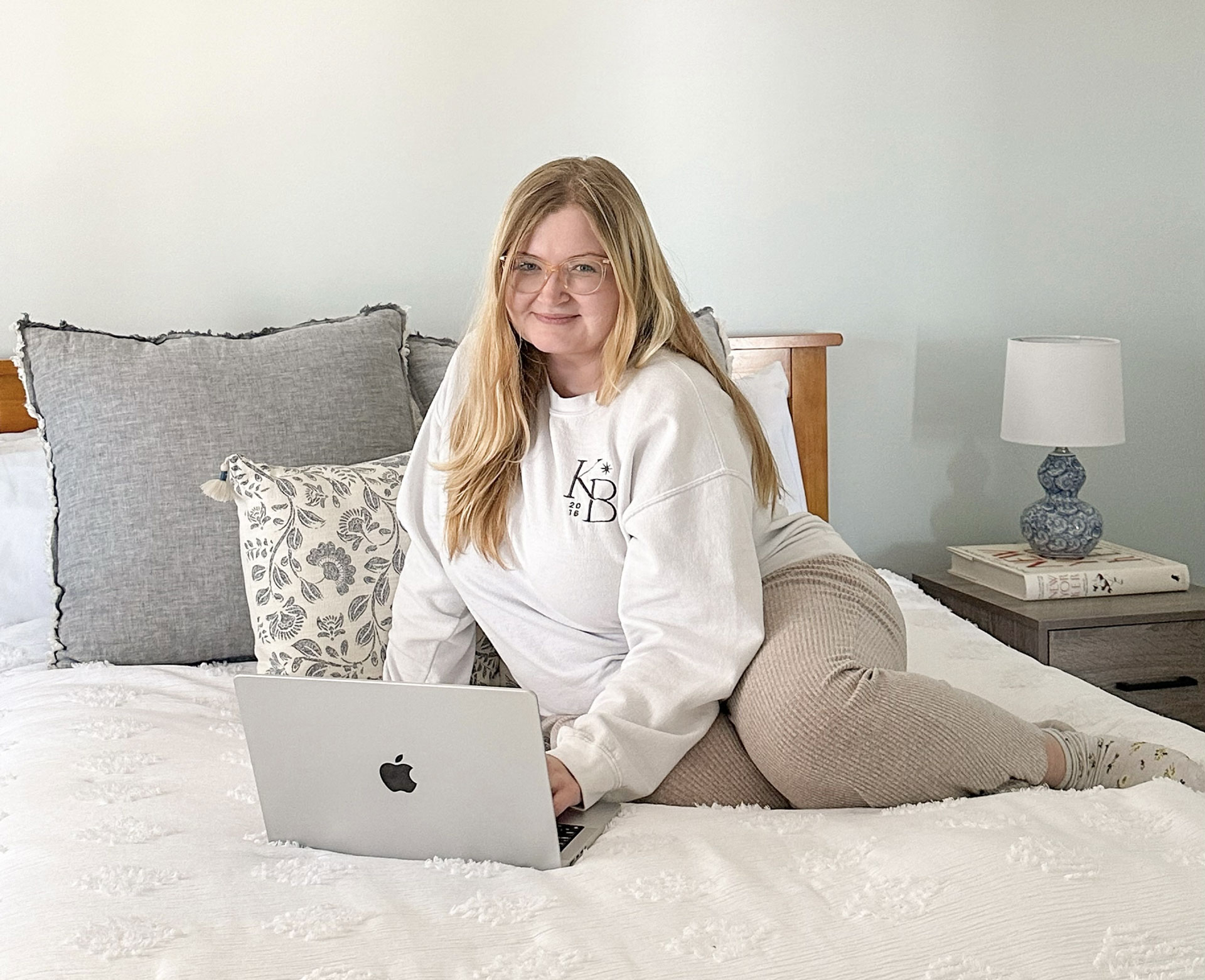 Woman sitting on bed with laptop