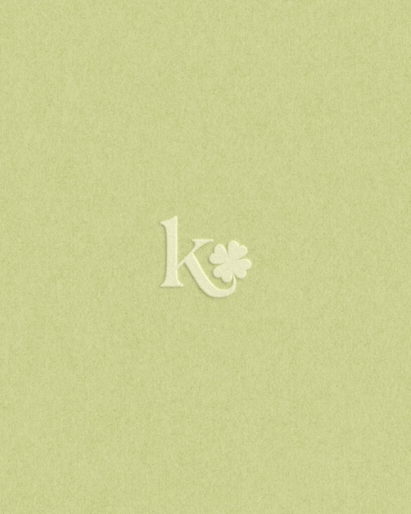 K icon with green clover emblem