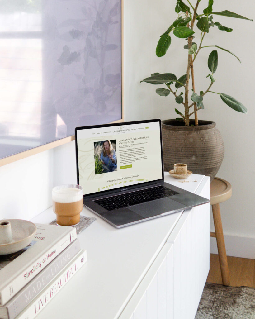 Laptop sitting on white counter showing website design for landscape company