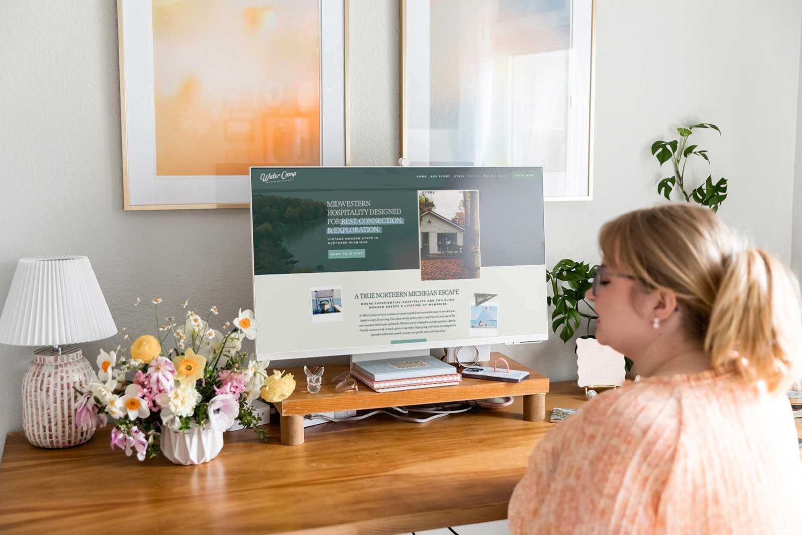 woman with blonde hair sitting at desk designing website for Water Camp