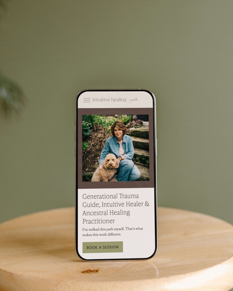 iphone showing website for Intuitive healing by Julie sitting on wood stool in front of olive green backdrop