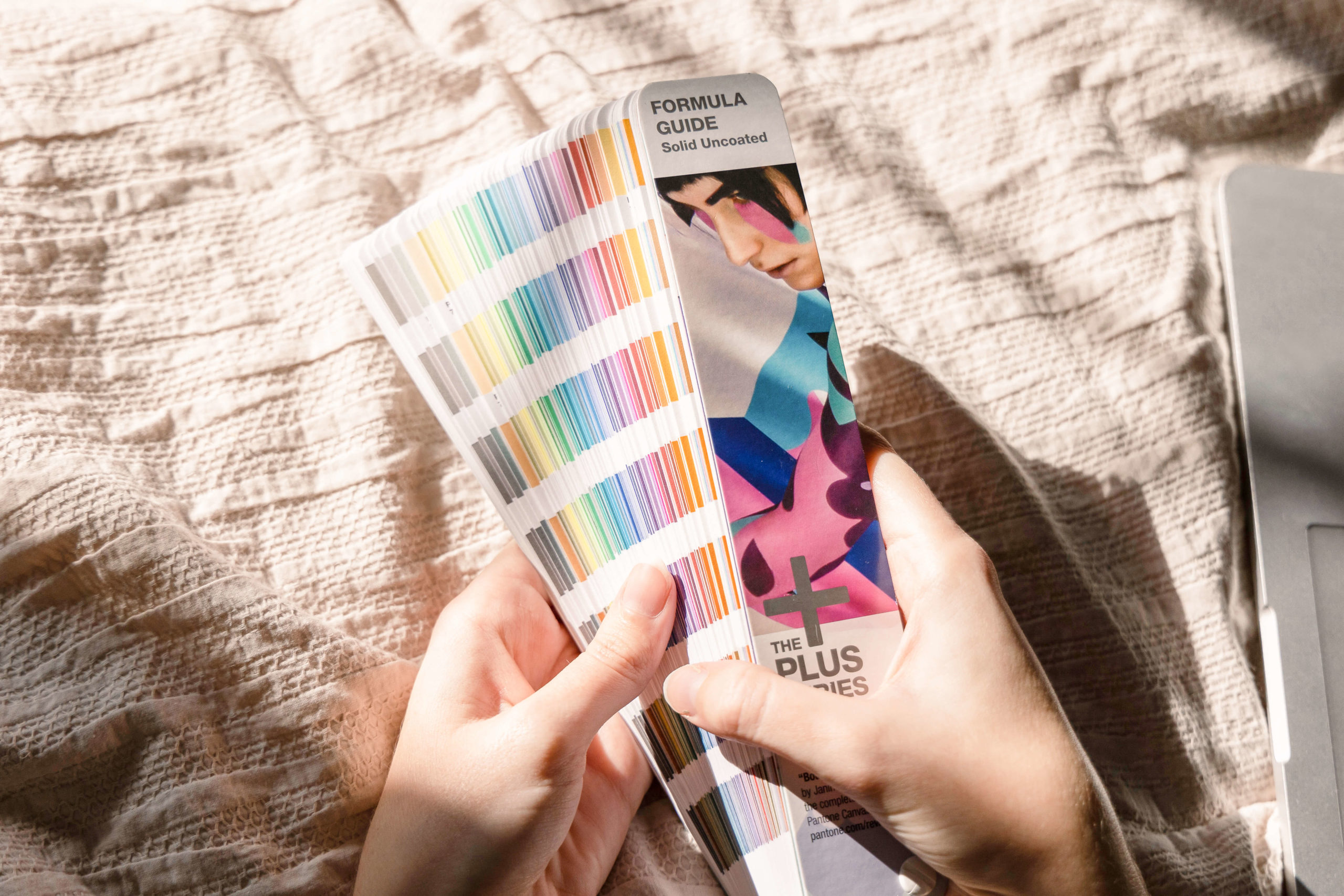 Hands holding Pantone swatch book to create color palette