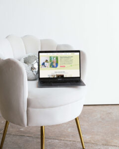 Kate Fleming senior photographer Showit website design shown on laptop sitting on light pink cream chair with disco ball